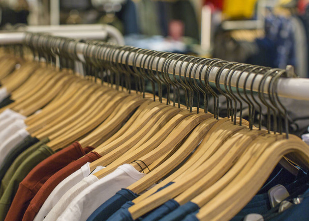 La ropa cuelga en un estante en una tienda de ropa de diseño. Concepto de compra y venta
. - Foto, imagen