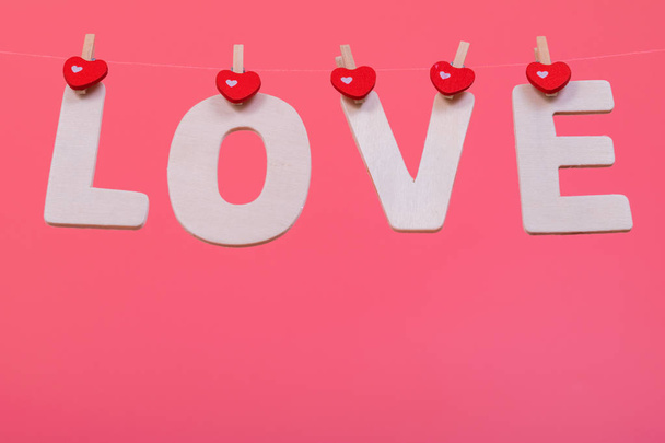 Word LOVE hang on pink color background, valentine - Фото, зображення