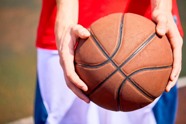 Vista cercana del hombre sosteniendo el baloncesto en las manos
 - Foto, imagen