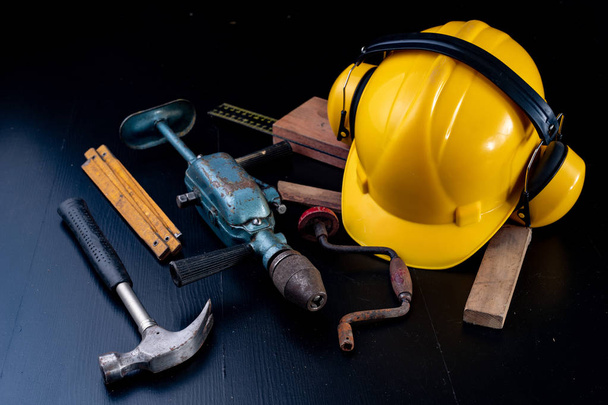 Tools for a carpenter on a workshop table. Accessories for a production worker. Dark background. - Photo, Image