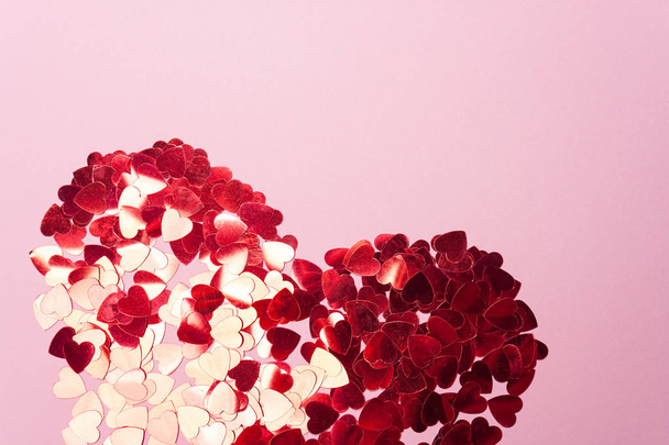 Valentine's day. Heart of red sequins on pink background - Foto, imagen