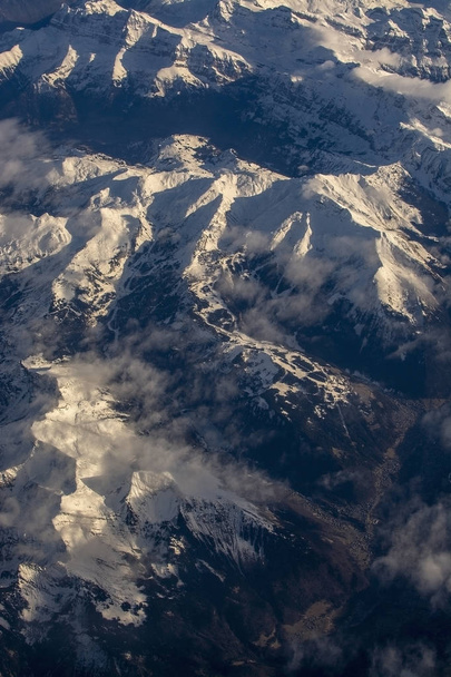Švýcarské Alpy se zasněženými vrcholky hor letecký výhled na východ během odpoledního letu v prosinci - Fotografie, Obrázek