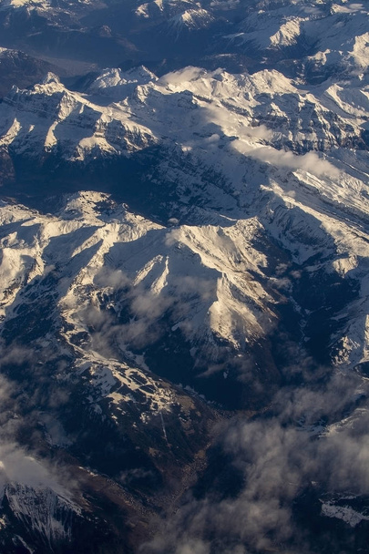 Alpy Szwajcarskie ze śnieżnymi szczytami gór widok z powietrza na wschód podczas popołudniowego lotu w grudniu - Zdjęcie, obraz