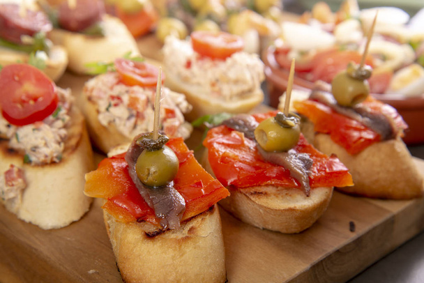 Pequenos aperitivos em espeto com queijo, azeitonas e anchova. Tapas ou antipasto alimentos
 - Foto, Imagem