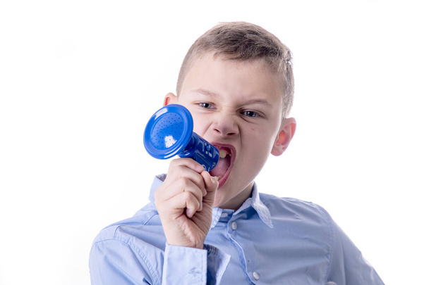 Αγόρι που φωνάζει πολύ δυνατά σε ένα μικρό μπλε τηλεβόα με ανοιχτό το στόμα - Φωτογραφία, εικόνα