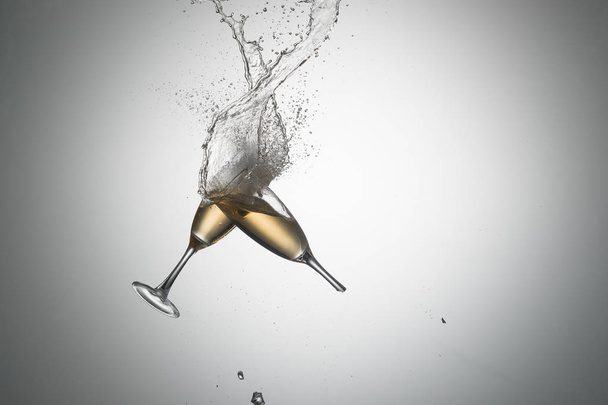 Літаючі келихи з наливним спиртом на градієнтному фоні. Ігристе вино. Біле вино. Шампанське. алкоголь
 - Фото, зображення