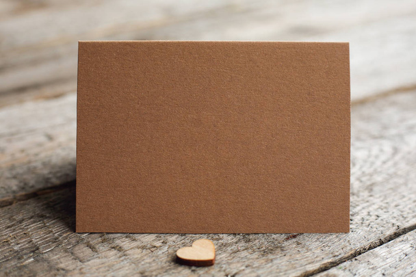 Prázdný hnědý papír blahopřání s kopírovacím prostorem pro text a dřevěné srdce, Valentines koncept - Fotografie, Obrázek