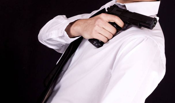 Man in zwart pak pistool in de hand te houden. Geheim agent, maffia, lijfwacht concept. - Foto, afbeelding