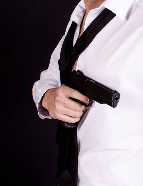 Un homme en costume noir tenant son arme à la main. Agent secret, mafia, concept de garde du corps
. - Photo, image