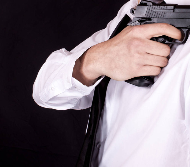Hombre de traje negro sosteniendo el arma en la mano. Agente secreto, mafia, concepto de guardaespaldas
. - Foto, imagen