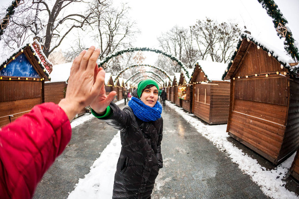 女性のヨーロッパの都市への旅行します。少女は、友人に 5 を与えます。美しいウクライナの都市の観光スポット。雪に覆われた通りに観光します。冬の休日。飾られた街を歩きます。クリスマス. - 写真・画像