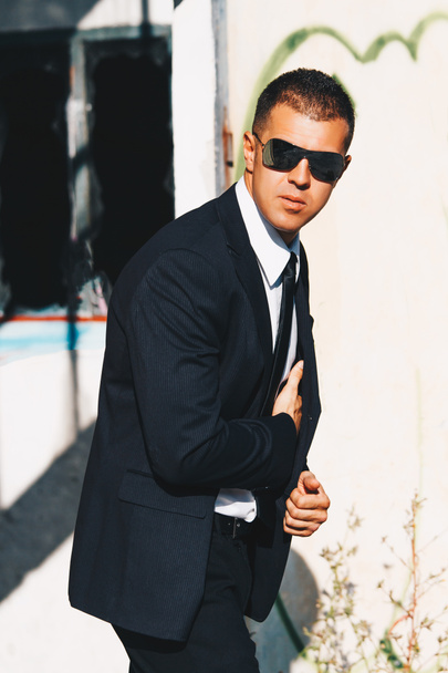 Handsome man in black suit and sunglasses. Secret agent, mafia, bodyguard concept. - Photo, Image
