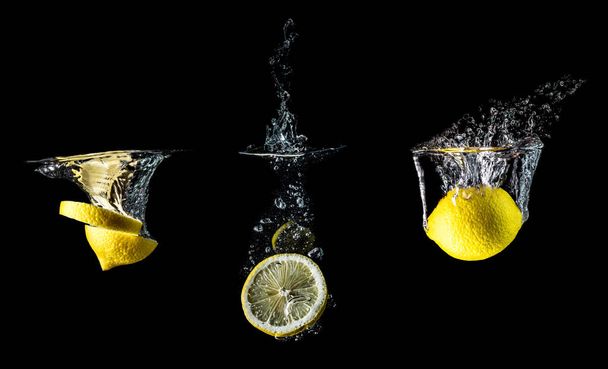 Composición de tres limones que caen en un primer plano de agua, macro aislados sobre un fondo negro. Gran tamaño grande
. - Foto, Imagen