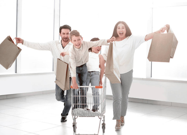 Full length portrait of a young family standing with shopping cart - Foto, afbeelding