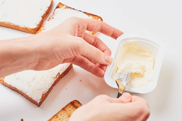 Ręka kobiety zrobić kanapkę, spred tosty z chleba z serem - Zdjęcie, obraz