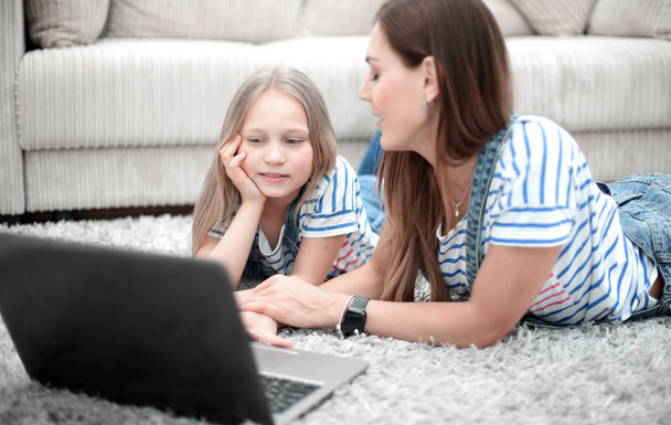 mother and daughter using a laptop in their home - Foto, Imagem