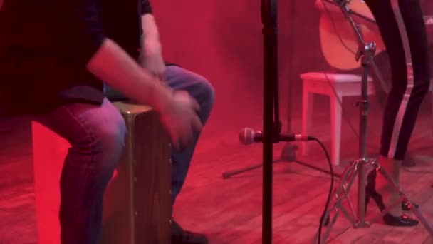 Teljesít egy dal rá eső részét a színpadon, a vörös fény, és füst, háttérben a show alatt zenekar dobosa. - Felvétel, videó