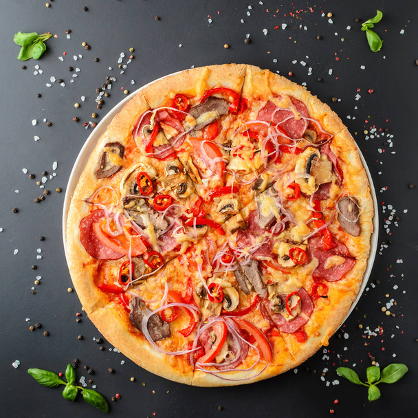 Pizza italiana em um fundo escuro, vista superior
 - Foto, Imagem