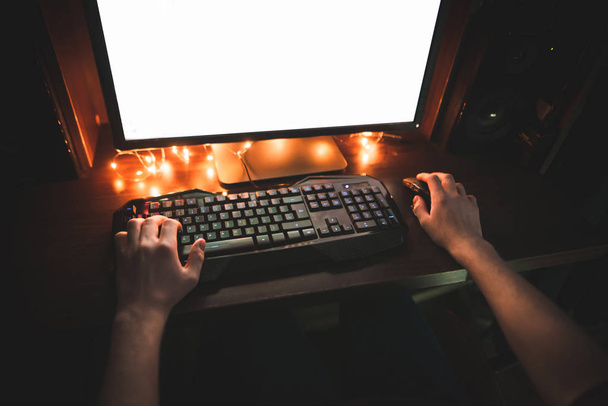 Mani di un uomo che lavora di notte su un computer vista dall'alto. Gamer gioca home videogiochi su un computer, tastiera e mani close-up. Concetto di giocatore. Contesto
. - Foto, immagini