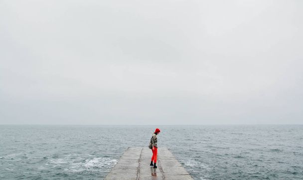 Mujer caminando en la playa vacía en invierno. Foto de arte con película añadida y filtro de grano
 - Foto, imagen