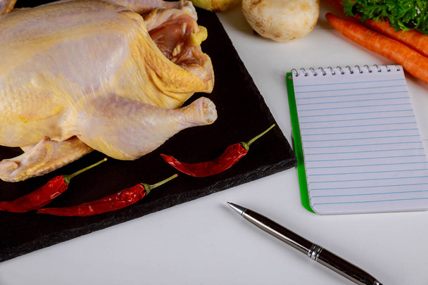 Raw mini chicken on wooden cutting board with a prescription notebook - Photo, Image
