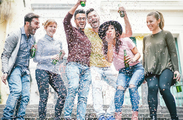 Grupo de amigos felizes fazendo festa bebendo cerveja e jogando confete - Jovens millennial pessoas se divertindo celebrando aniversário e rindo juntos - Amizade, conceito de estilo de vida de férias da juventude
 - Foto, Imagem