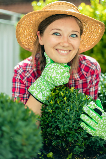 Frohliche Frau im Garten beim Pflanzenpflege - Фото, зображення