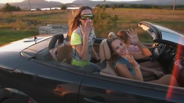 Meninas enviam um beijo dirigindo um carro cabrio
 - Filmagem, Vídeo