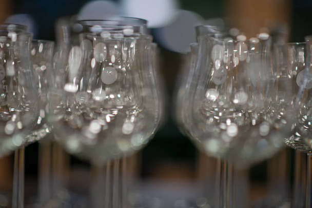 Несколько рядов пустых бокалов для питья, бокалы для вина на столе в буфете в ресторане
 - Фото, изображение