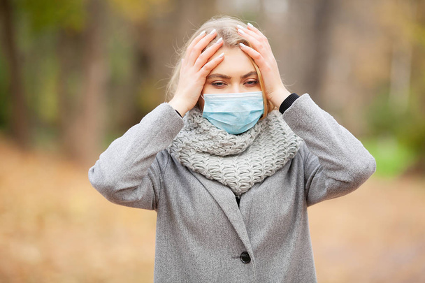Cold and flu. Woman with a medical face mask at outdoor - Fotó, kép