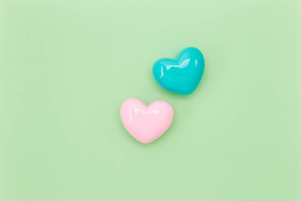 Pastel pink heart with pastel blue heart on Green paper background, valentine love day concept. minimal style concept  with negative space for your content - Фото, зображення