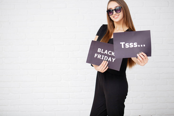 Shopping. Woman holding black text board on light background in black friday holiday - Photo, Image