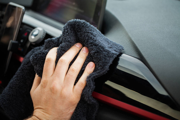 Уборка машины. Рука с микроволокном ткани чистки салона автомобиля
 - Фото, изображение