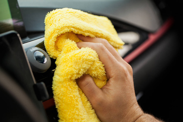 Cleaning car. Hand with microfiber cloth cleaning car interior - Fotoğraf, Görsel