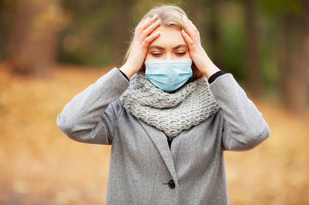 Erkältung und Grippe. Frau mit medizinischer Gesichtsmaske im Freien - Foto, Bild