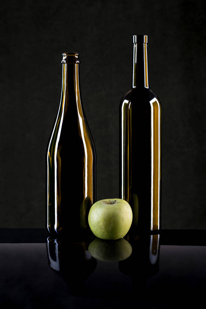 Stillleben mit einem Apfel und Glasflaschen - Foto, Bild