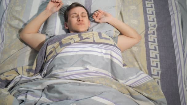 Kater, Schlaf und Menschen-Konzept - Mann mit Kopfschmerzen wacht zu Hause im Bett auf - Filmmaterial, Video
