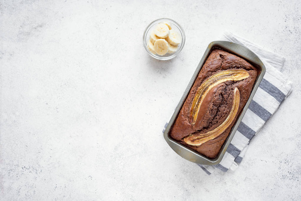 Homemade Chocolate Banana Bread on white background, copy space. Healthy banana bread or cake with dark chocolate for breakfast, top view. - Foto, Imagen