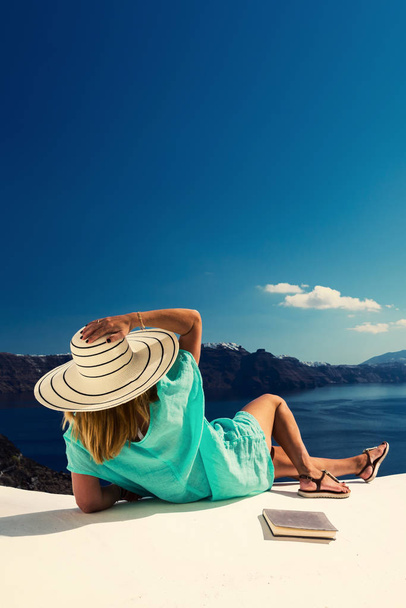Luxury travel vacation woman looking at view on Santorini island in Greece. Amazing view of sea and Caldera. - Photo, Image