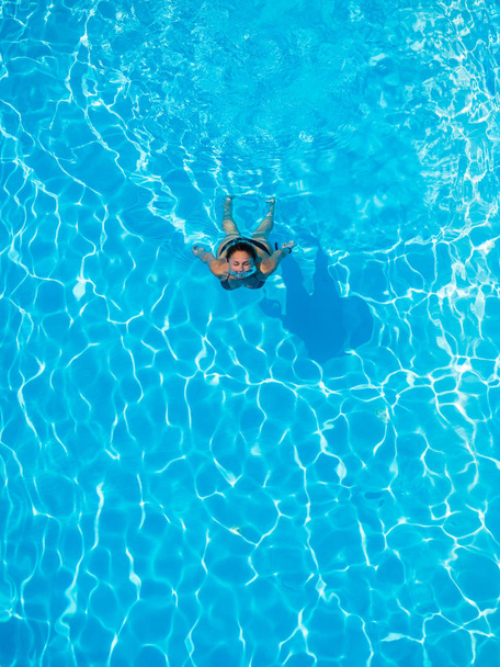 Top view of a woman swimming in the pool - Fotó, kép