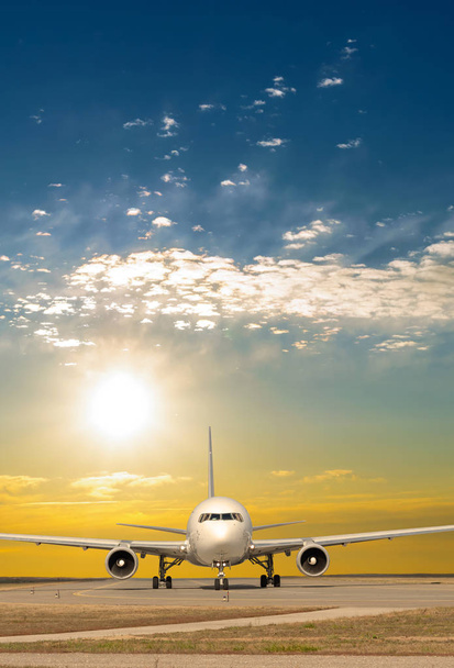 Avión jet de pasajeros en la pista en la vista frontal del aeropuerto al amanecer
 - Foto, imagen