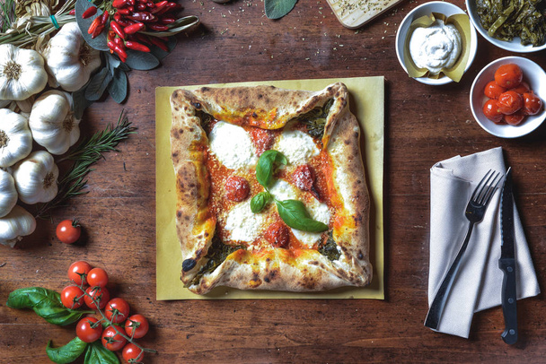 Hintergrundansicht Italienische quadratische Pizza mit Kirschtomaten, Sauce, Mozzarella und Basilikum auf Rahmenkomposition - Foto, Bild