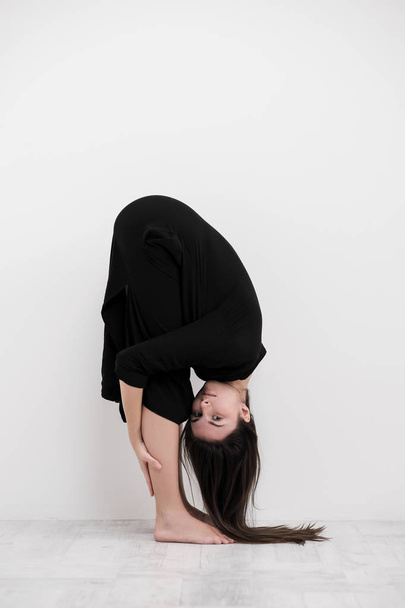 Sporty young woman doing yoga practice on white background - concept of healthy life and natural balance between body and mental development. - Φωτογραφία, εικόνα