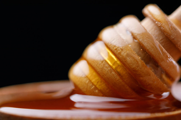 Honey spoon comb dipping in fresh aromatic honey. Close-up. Macro. - Foto, imagen