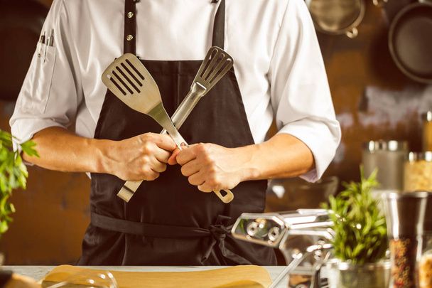 Cooking, profession and people concept - male chef cook making food at restaurant kitchen - 写真・画像