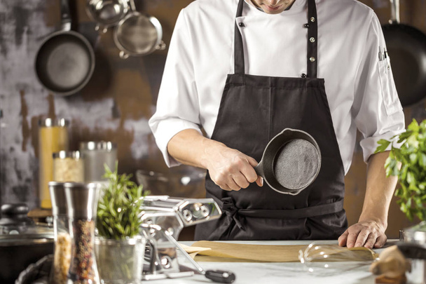 Cooking, profession and people concept - male chef cook making food at restaurant kitchen - Foto, imagen