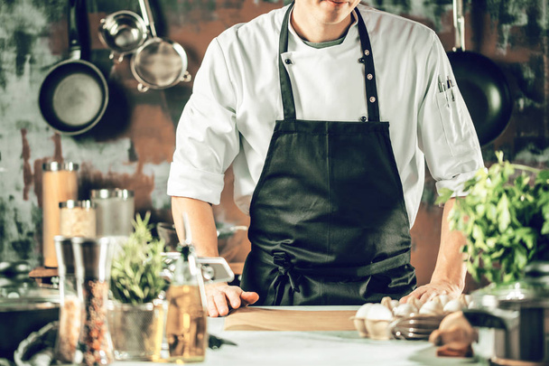 Cooking, profession and people concept - male chef cook making food at restaurant kitchen - Foto, Bild