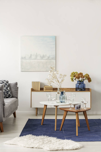 Light blue and grey abstract painting on empty white wall of stylish living room - Photo, image