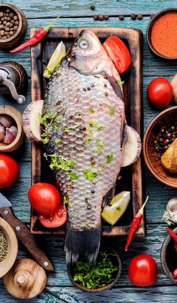 Fresh fish with ingredients on rustic cutting board.Cooking concept. - Foto, Bild