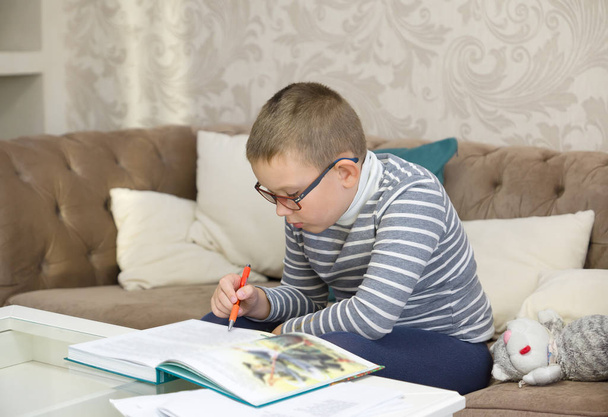 молодий хлопчик вчиться читати велику книгу
 - Фото, зображення